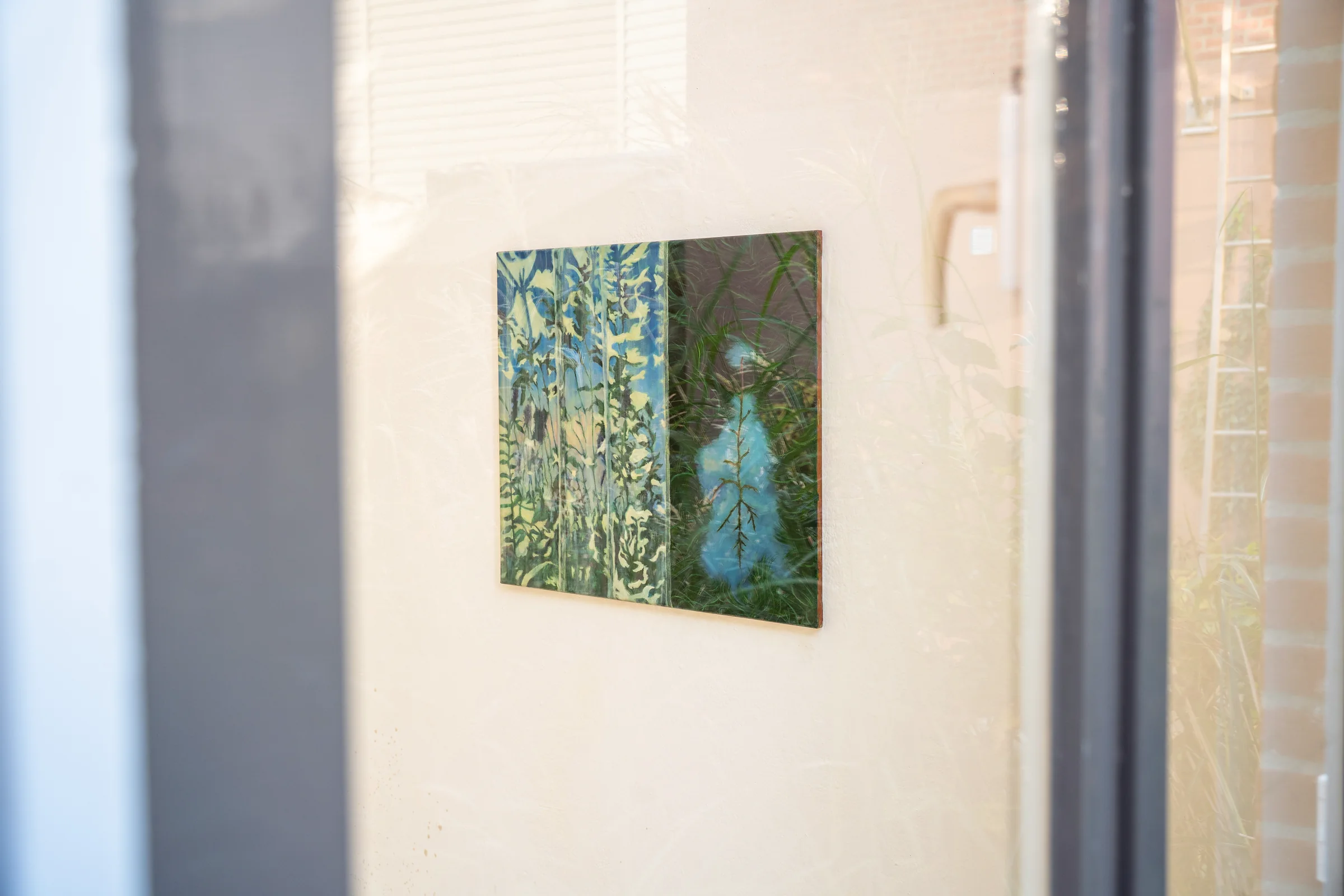 A painting displayed behind a window